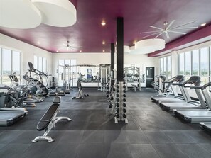 A modern gym with treadmills, weight machines, and free weights.