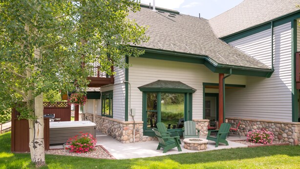 Une maison dotée d’un patio aménagé avec des meubles d’extérieur et un jacuzzi.