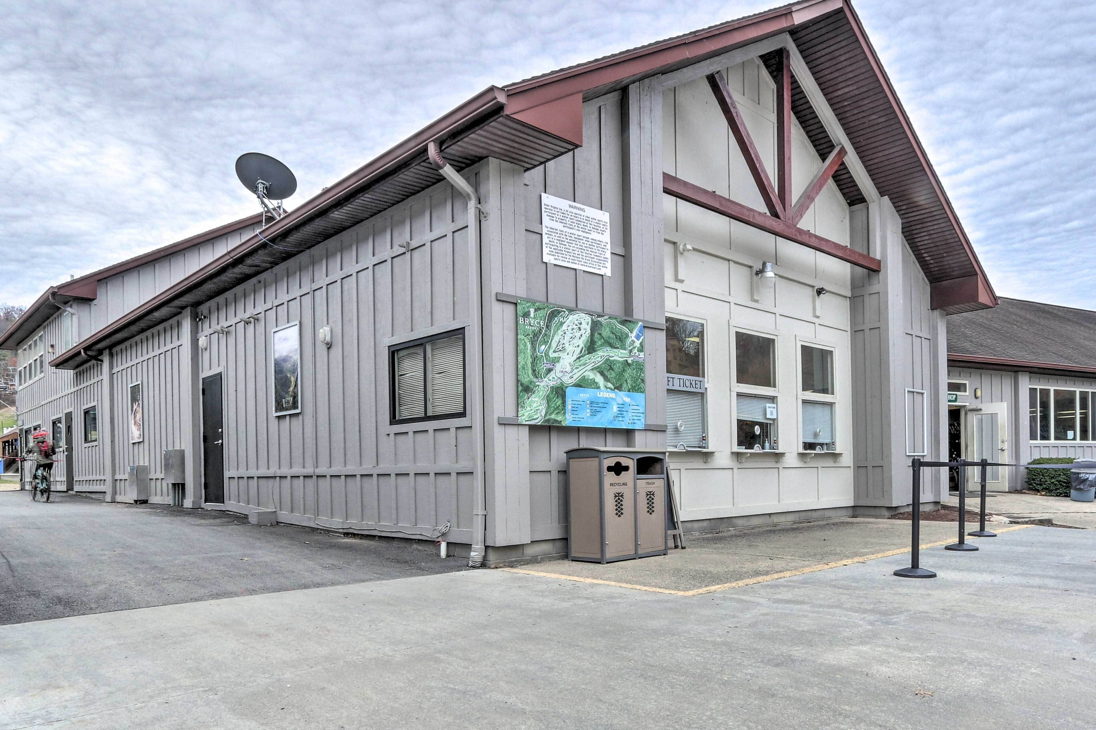 Un bâtiment doté d’une antenne parabolique, d’une enseigne et d’une poubelle de recyclage.