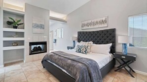 Een moderne slaapkamer met een groot bed, een open haard en uitzicht op de omgeving.