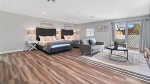Een moderne slaapkamer met een groot bed, een bank en een bijzettafeltje.