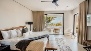Une chambre d’hôtel moderne dotée d’un grand lit, d’un balcon avec vue, d’un bureau et d’une chaise.