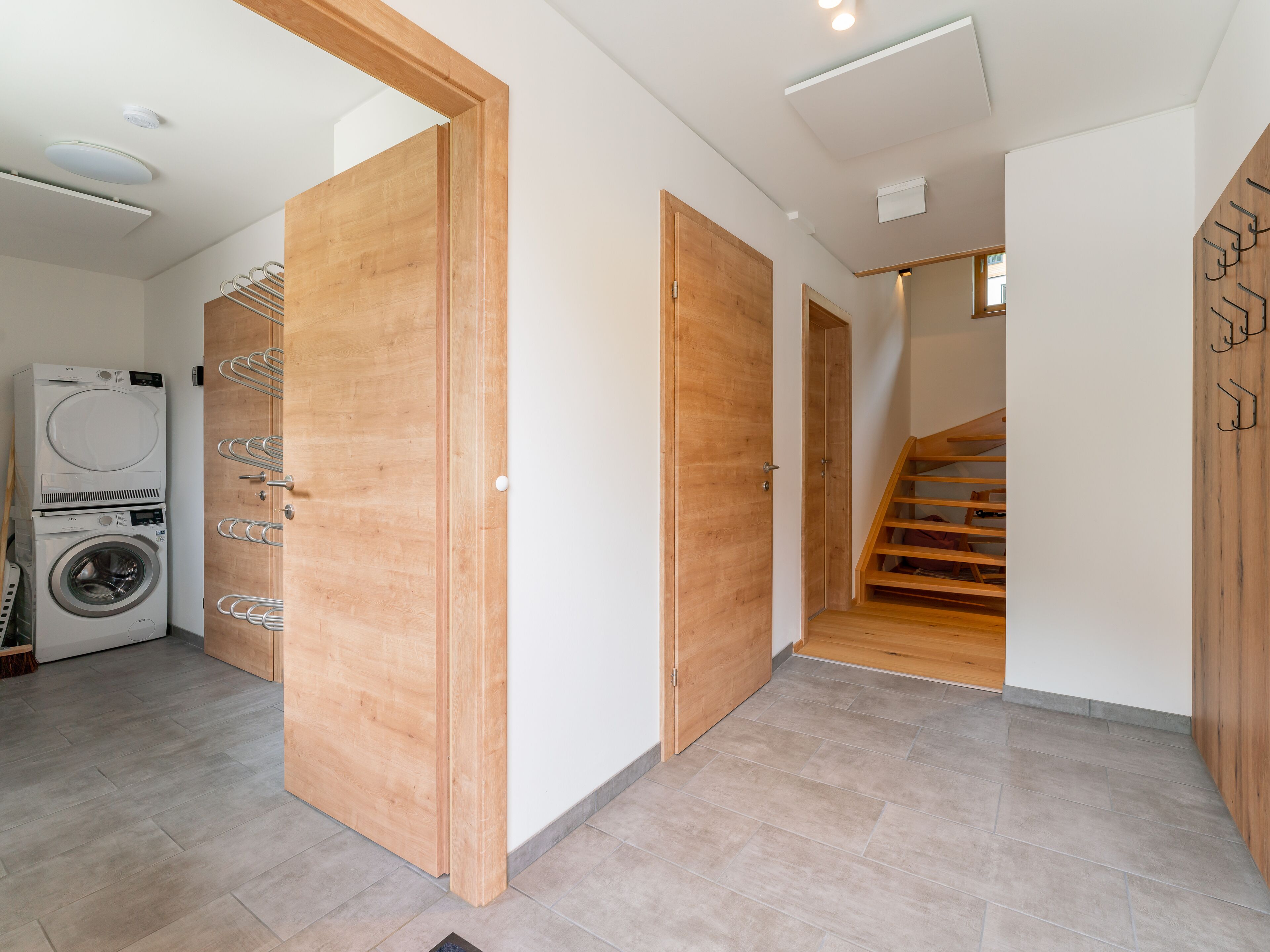Un intérieur moderne avec des portes en bois, un lave-linge et un escalier.