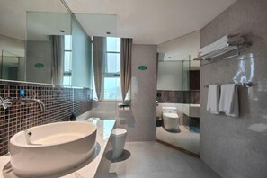 A modern bathroom with a large vessel sink, a toilet, and a mirror. - New Joy Hotel (Internatial Trade Spring Department Store Shopping) (Zunyi)