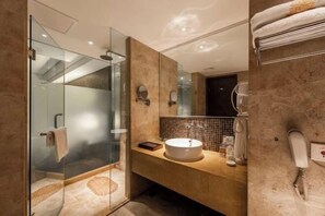 A modern bathroom with a glass-enclosed shower, a beige vanity with a sink, and a large mirror. - New Joy Hotel (Internatial Trade Spring Department Store Shopping) (Zunyi)