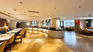 A modern restaurant with a curved counter, wooden flooring, and a variety of seating options. - New Joy Hotel (Internatial Trade Spring Department Store Shopping) (Zunyi)