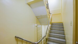 Un escalier avec des rampes et une main courante en métal, menant à l’étage supérieur.