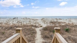 A beach path leading to the ocean with a wooden railing on the left. - "Mocean Granted" - Oceanfront Home, 5 Bedrooms / 4 Bathrooms (Holden Beach)