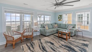 A living room with a sectional sofa, two armchairs, a coffee table, and a ceiling fan. - "Mocean Granted" - Oceanfront Home, 5 Bedrooms / 4 Bathrooms (Holden Beach)