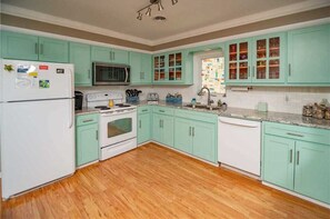 A kitchen with teal cabinets, a white refrigerator, a microwave, a stove, and a dishwasher. - "Turtles Nest" - Oceanfront Duplex, 3 Bedrooms / 3 Bathrooms (Holden Beach)