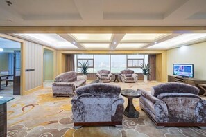 A spacious living room with a large window, multiple sofas, a coffee table, and a television. - Hanjiang International Hotel (Danjiangkou)