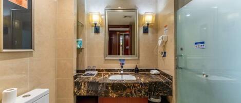 Un baño moderno con un lavamanos de mármol, un inodoro y una cabina de ducha de vidrio.