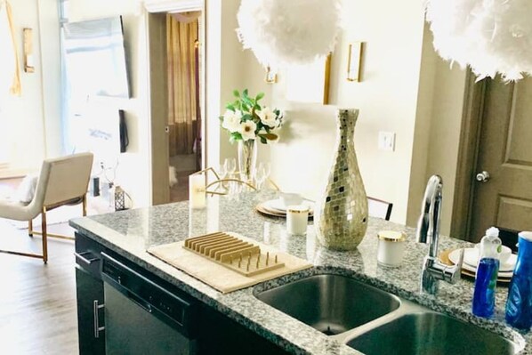 Enjoy cooking in this well-equipped kitchen with a granite countertop, stainless steel sink, and ample space for meal preparation.