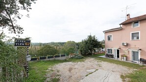 Ein Gebäude mit einem Schild, das 'River View 67' zeigt, einer Schotterauffahrt und einem kleinen Garten.