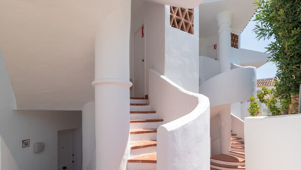 A white building with a spiral staircase, a door with a number sign, and a small window. - Bright and Cosy Apartment with Sea Views, Shared Pool and Wi-Fi (Mijas Costa)