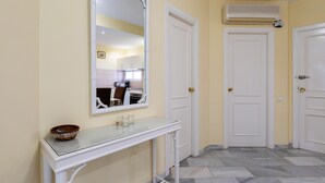 A hallway with a white console table, a mirror, and a door leading to a kitchen. - Bright and Cosy Apartment with Sea Views, Shared Pool and Wi-Fi (Mijas Costa)