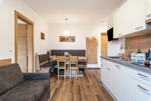 Un espacio habitable compacto con kitchenette, zona de comedor y área de estar.