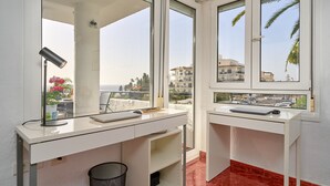 Un baño moderno con dos lavamanos, un espejo grande y vistas a la playa y edificios.