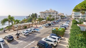 Un hotel costero con aparcamiento, vistas al mar y un paseo peatonal.