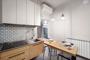 Une cuisine moderne dotée d’un plan de travail en bois, d’un évier et d’un coin repas avec des tabourets.