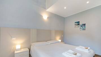 Een slaapkamer met een bed, nachtkastjes en wanddecoratie.