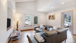 A modern living room with a leather sofa, a coffee table, and a TV. - Ca di Perti Apartment 3 with Mountain View (Finale Ligure)