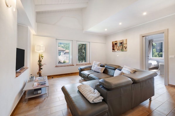 A modern living room with a leather sofa, a coffee table, and a TV.