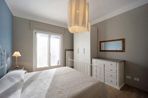 Une chambre à coucher avec un lit, une commode, un miroir et une lampe.