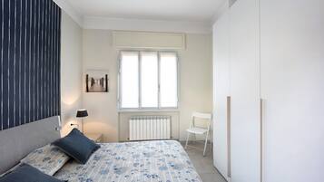 Une chambre à coucher avec un lit, une chaise, un radiateur et une fenêtre.