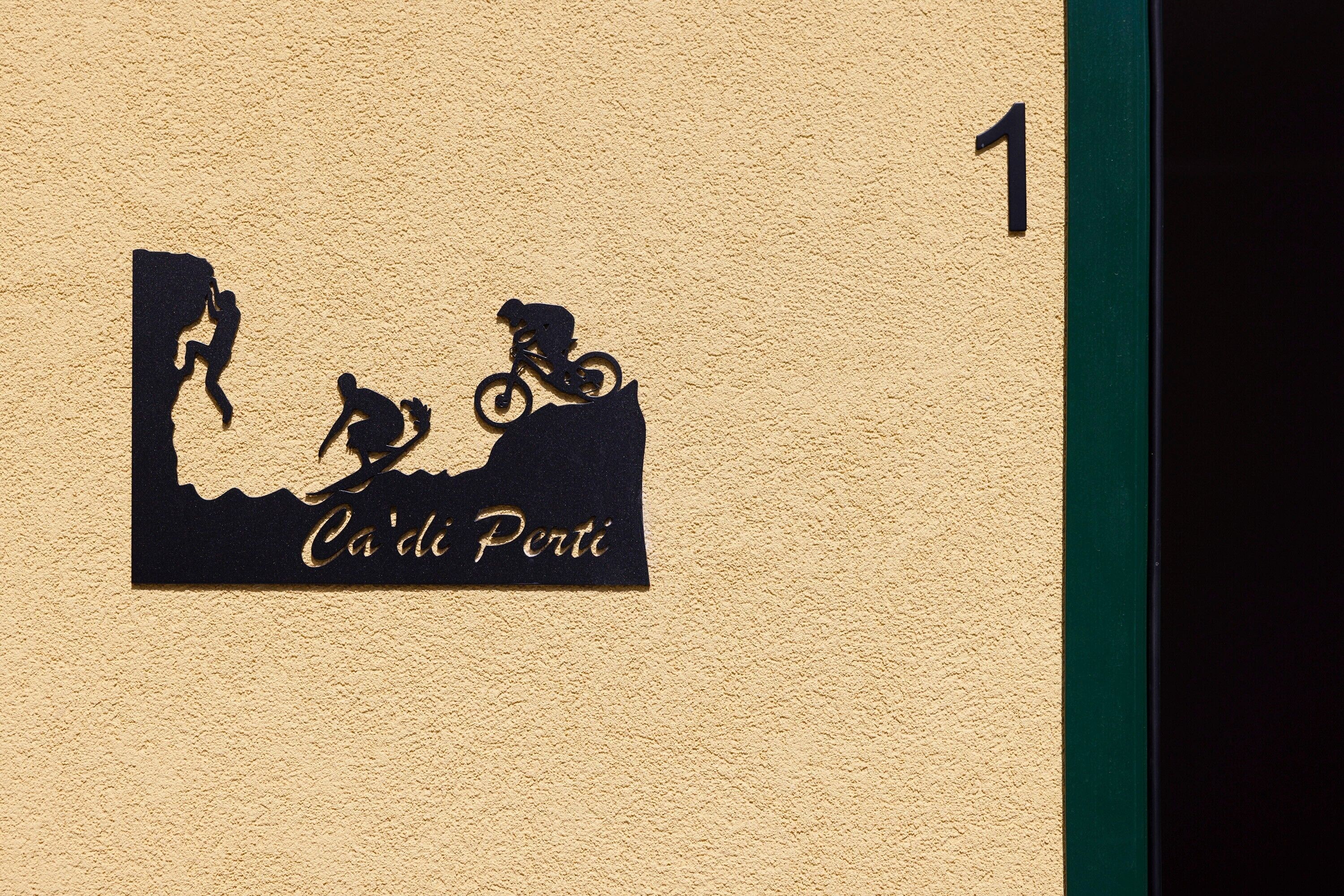 A wall with a silhouette of a mountain biker and a cyclist, and the text 'Ca'di Porti'.