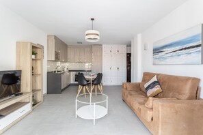 A modern living space with a kitchen, dining area, and a sofa.