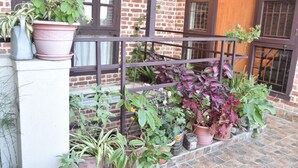 A balcony with potted plants and a metal railing. - Tanani Newa Home (FishTail) (Lalitpur)