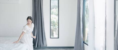 A room with a bed, a window, and curtains.