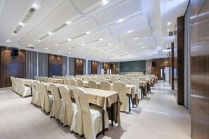 A conference room with rows of tables and chairs, a large screen, and a modern ceiling design. - Chongqing Shengshi Jia hua Hotel (Jiangjin Shuangfu Branch) (Chongqing)