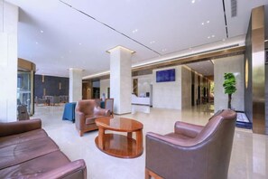 A modern lobby with leather seating, a reception desk, and a reception area.