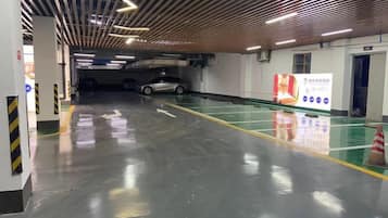 A parking garage with clear directional arrows on the floor, a clean and well-lit environment, and a visible exit door.