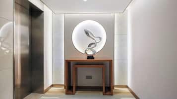 A hallway with a wooden console table and a circular light fixture.