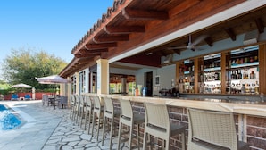 A bar area with a pool and outdoor seating. - Eriva Hotel (Acharavi)