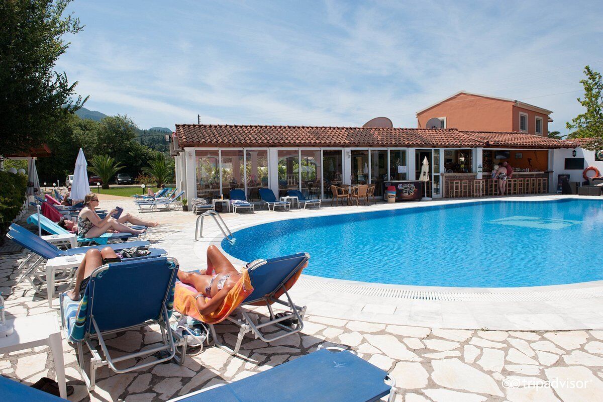 A pool area with lounge chairs and a bar.
