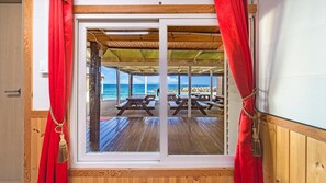 Une terrasse en bois avec des tables de pique-nique, donnant sur l’océan.