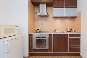 A compact kitchen with a microwave, oven, and sink.
