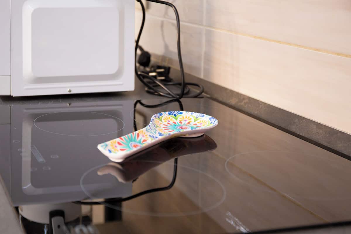 A microwave and a colorful object on a reflective surface.