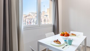 A dining area with a table set for breakfast, including croissants, oranges, and a glass of water. - Multisuite Palermo (Palermo)