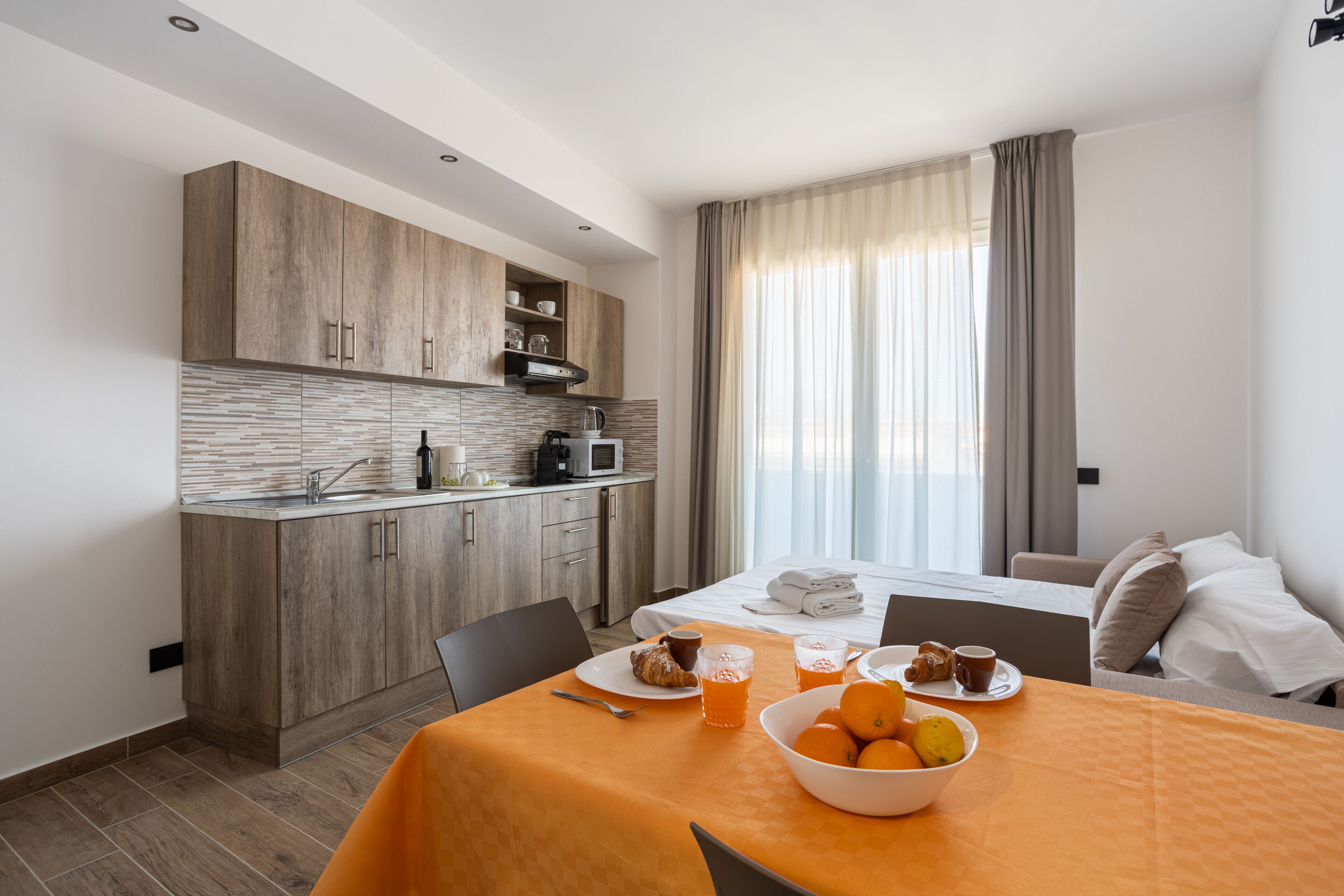 Una cocina moderna con armarios de madera y un comedor con una mesa dispuesta para el desayuno.