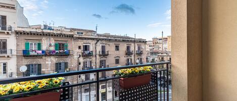 A balcony with flower boxes and a view of old buildings.