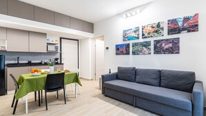 A modern living space with a kitchen, dining area, and a grey sofa. - Multisuite Palermo (Palermo)