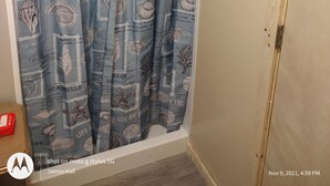 Ein Badezimmer mit Duschvorhang, der Muscheln und Seesterne zeigt.