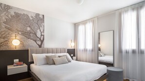 Una camera da letto moderna con un letto grande, comodini, una lampada a parete e uno specchio.