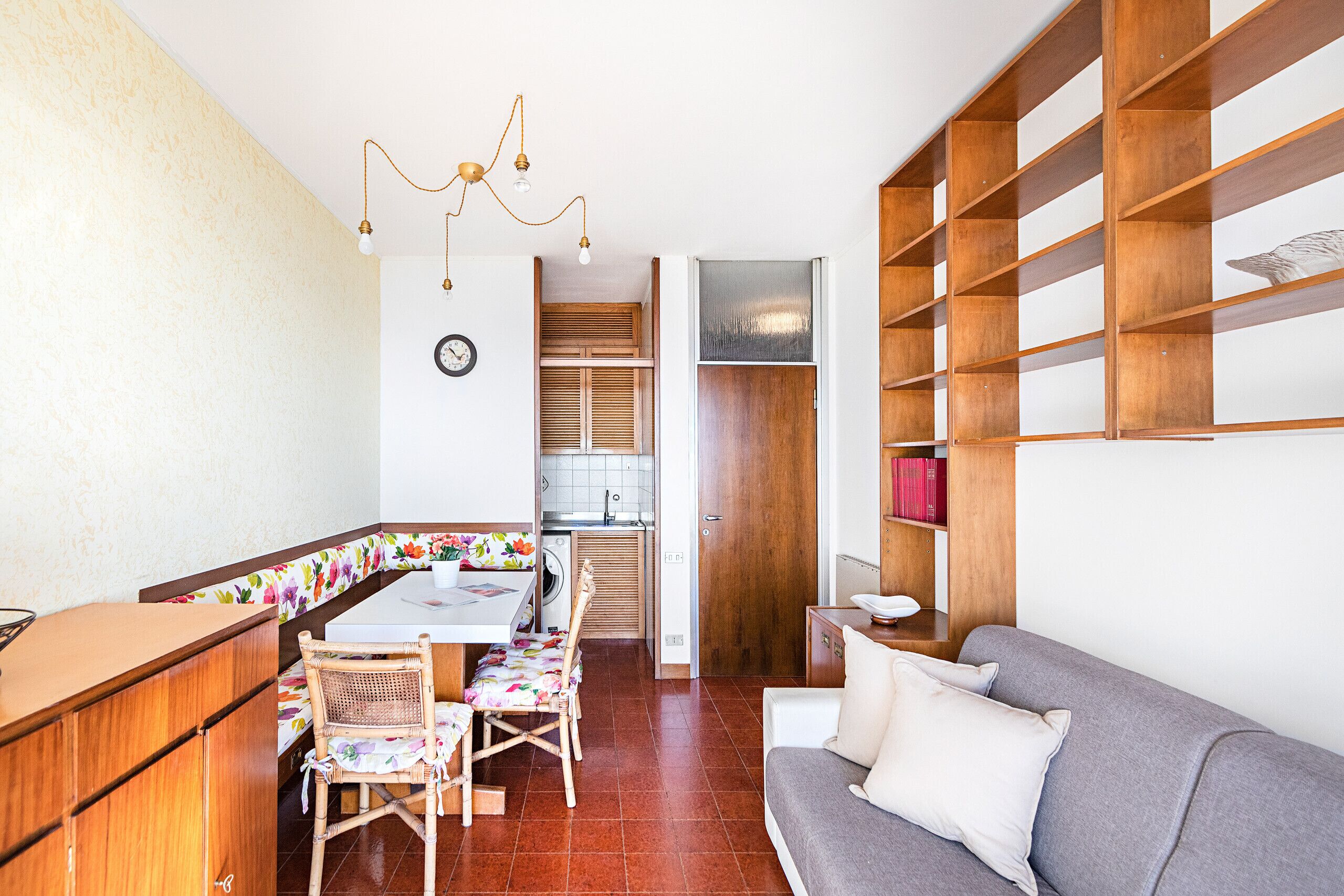 Un espacio habitable compacto con comedor, kitchenette y zona de estar.
