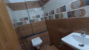 A bathroom with a toilet, sink, and shower.